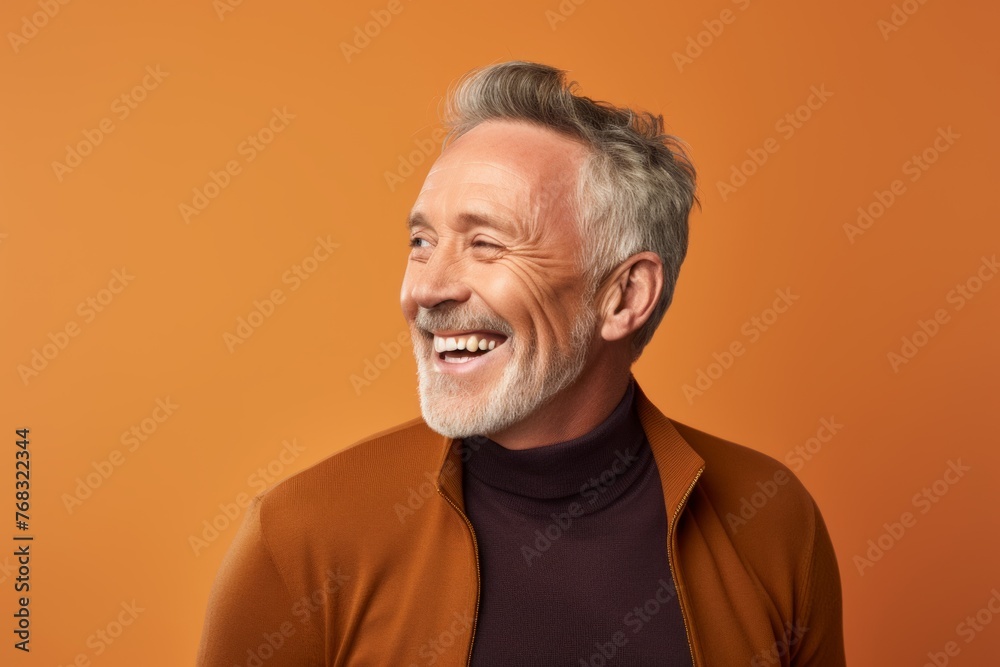 Portrait of a happy senior man with grey hair and beard on orange background Portrait of a happy senior man with grey hair and beard on orange background