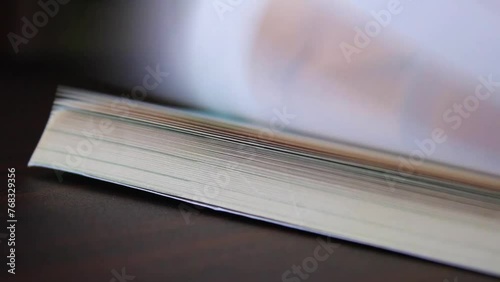 Hand finger flipping school textbook pages on table surface 1 photo