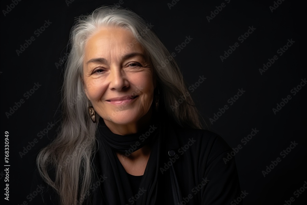 Portrait of a beautiful senior woman with gray hair on a black background