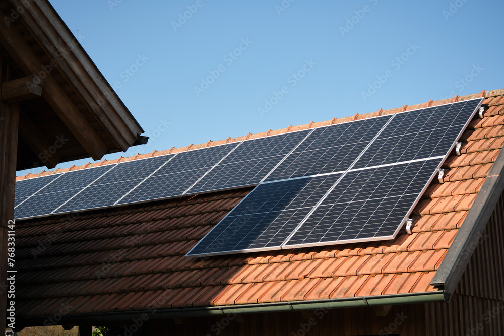 Solar panels on the roof of a house with red tiles Solar panels on the roof of a house with red tiles