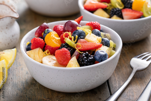 Fruit salad with fresh berries, bananas and apples in small bowls