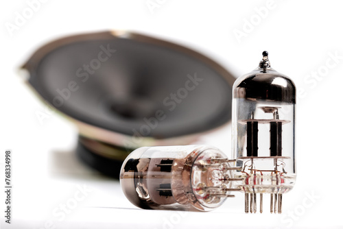 12AX7 style audio pre amplifier vacuum tubes in front of an out of focus loudspeaker in the background isolated on white photo
