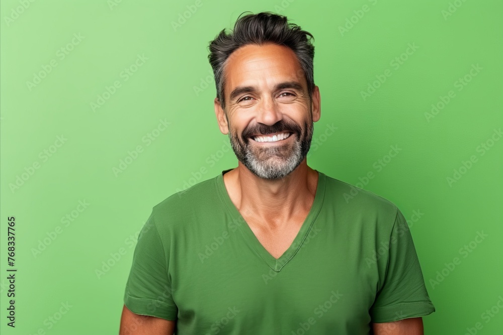Portrait of a handsome middle-aged man smiling against a green background