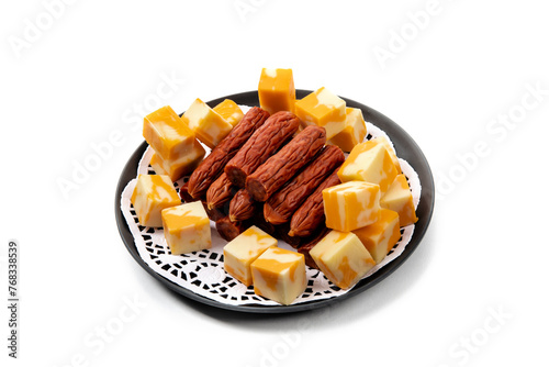 a plate of cheddar cheese cubes and pepperoni sausage chunks isolated on white photo