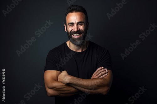 Handsome bearded man in black t-shirt smiling and looking at camera.