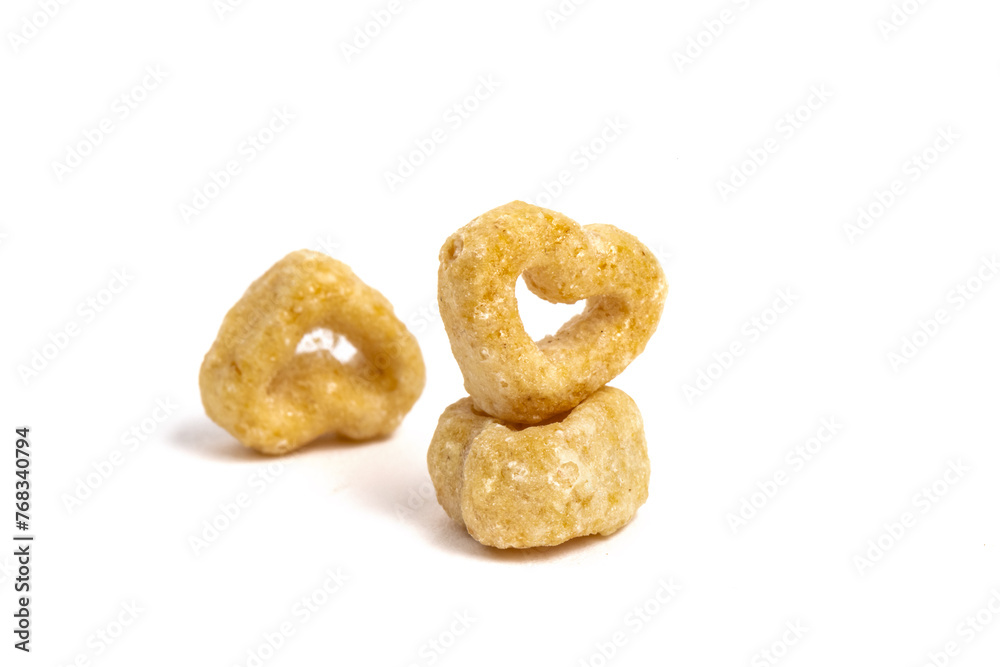 macro closeup of a a few heart shaped toasted oat puff cereal pieces isolated on white, 