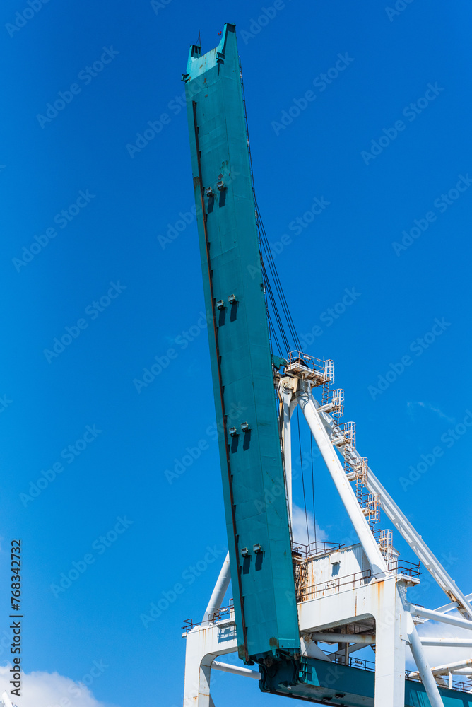 Gantry crane arm on the blue sky background. Container terminal of Miami sea port. Gantry crane arm on the blue sky background. Container terminal of Miami sea port.