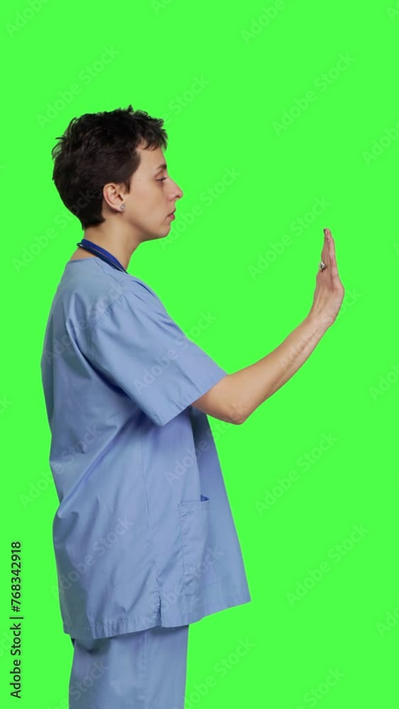 Profile Health specialist with blue scrubs showing stop sign in studio, standing against greenscreen backdrop. Nurse expressing denial and refusal with warning forbidden symbol, denying something Profile Health specialist with blue scrubs showing stop sign in studio, standing against greenscreen backdrop. Nurse expressing denial and refusal with warning forbidden symbol, denying something