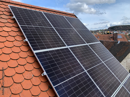 Solar panels on the roof of a house with red tiles
