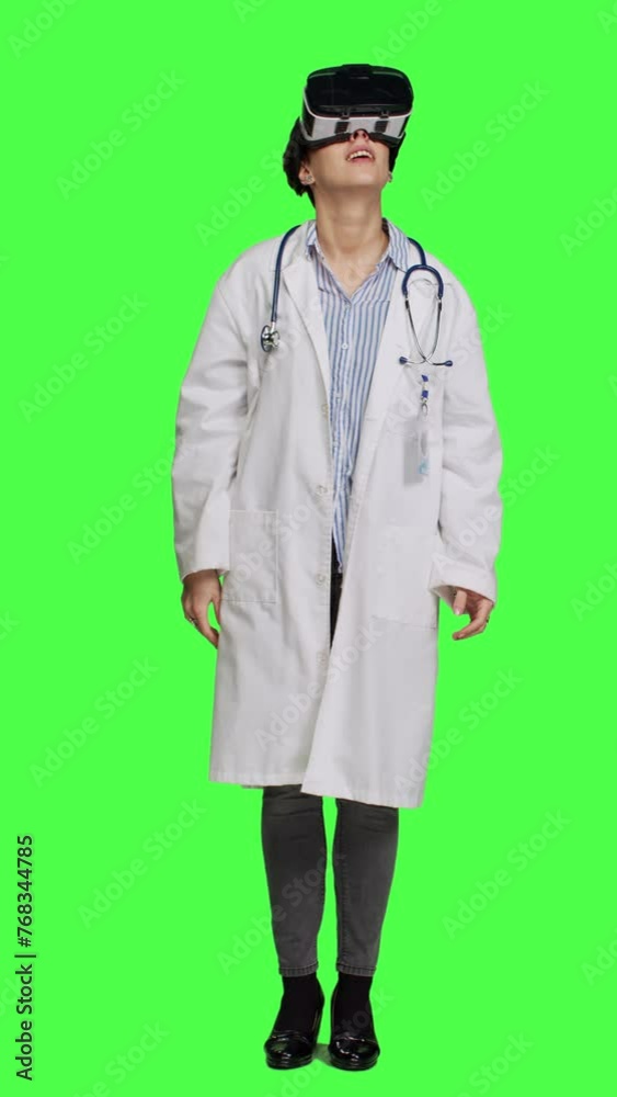 Front view Physician uses virtual reality interactive lens on headset in studio, checks diagnosis with artificial intelligence three dimensional tool. Doctor works with vr glasses against greenscreen Front view Physician uses virtual reality interactive lens on headset in studio, checks diagnosis with artificial intelligence three dimensional tool. Doctor works with vr glasses against greenscreen