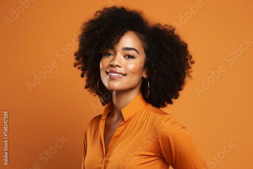 Beautiful african american woman with afro hairstyle in orange shirt