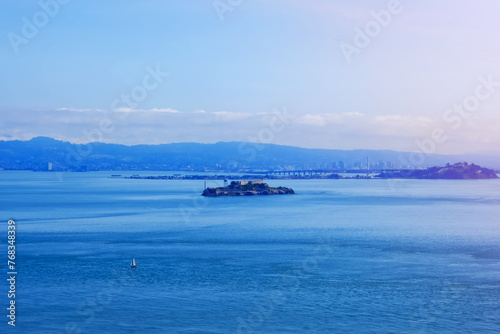 Scenic ocean view of Alcatraz island and San Francisco city from Golden Gate Bridge in sunlight landscape photo. California landmark.