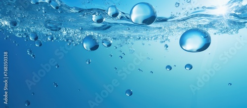 Bright and clear blue water surface with small bubbles floating on top in a close-up view, creating a serene and refreshing aquatic scene photo