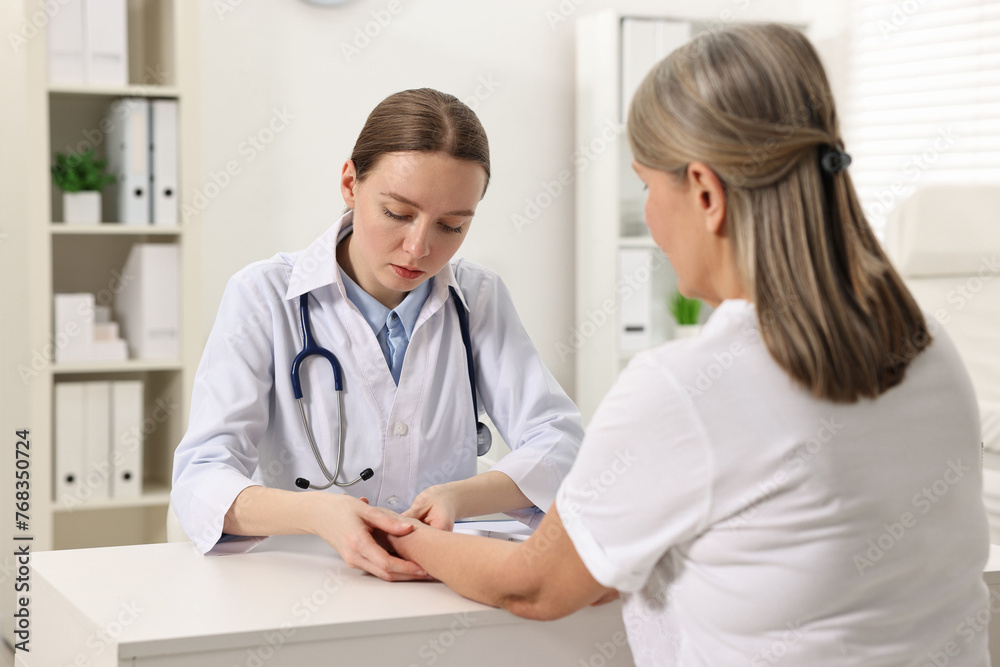 Arthritis symptoms. Doctor examining patient's wrist in hospital Arthritis symptoms. Doctor examining patient's wrist in hospital