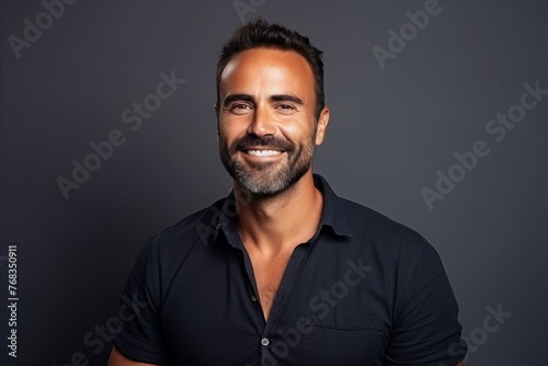 Portrait of a handsome middle aged man smiling at the camera over grey background.