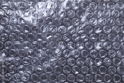 Transparent bubble wrap on black background, top view