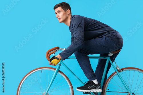 Young man riding bicycle on...