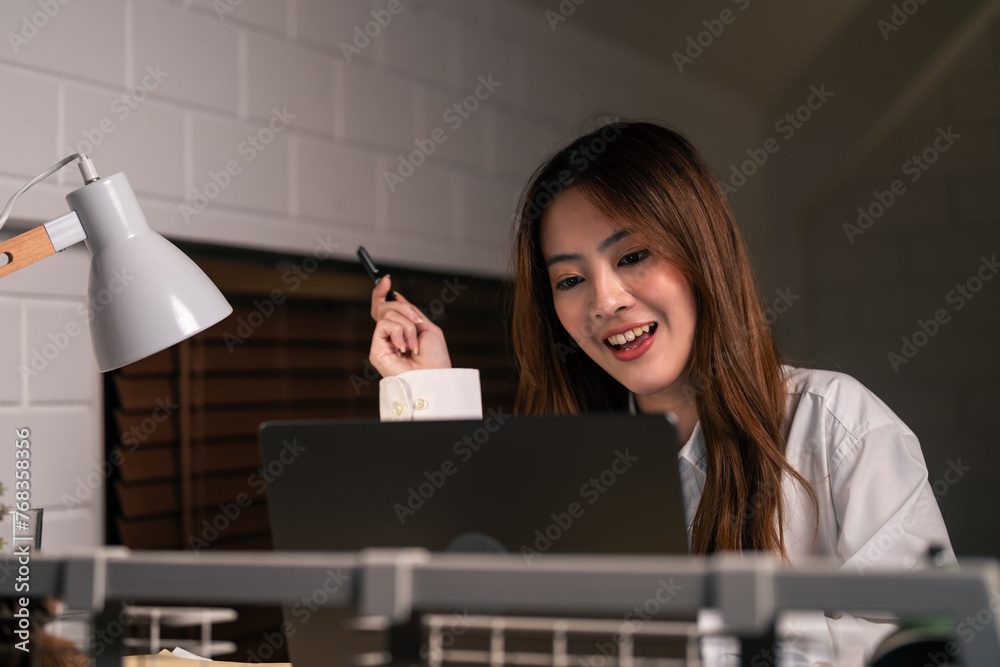 Asian young beautiful businesswoman working in bedroom at night time. 