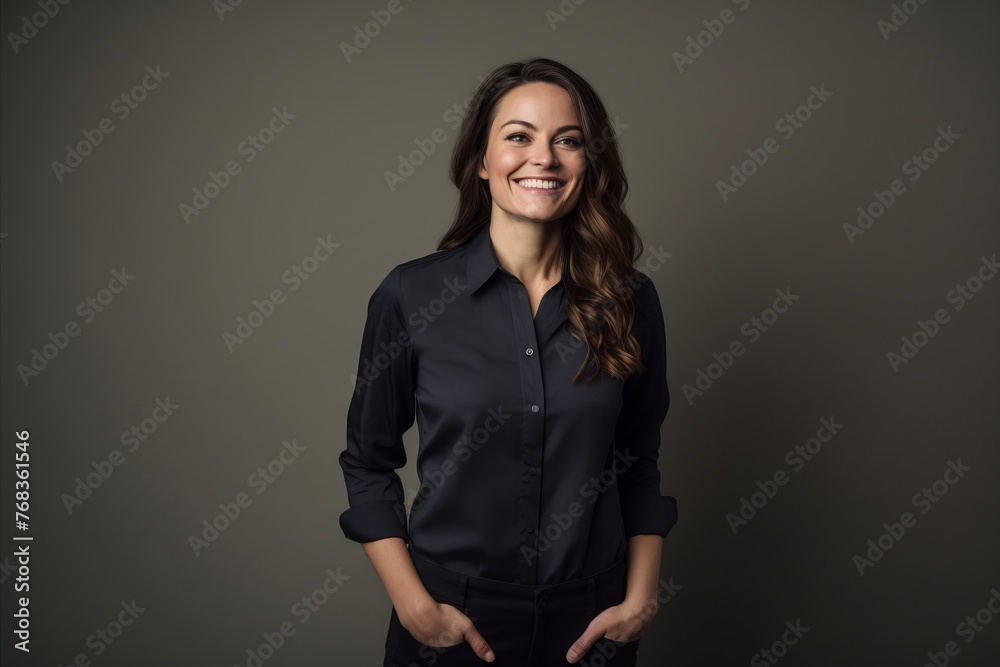 Portrait of a smiling business woman in black shirt on grey background Portrait of a smiling business woman in black shirt on grey background