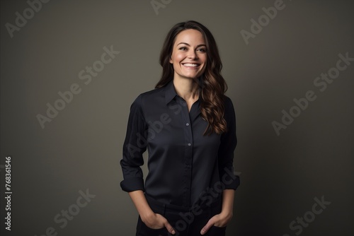 Portrait of a smiling business woman in black shirt on grey background