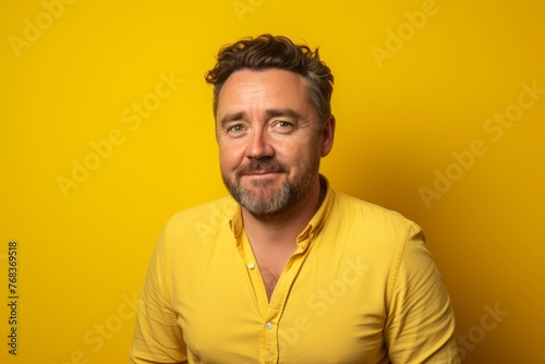 Portrait of a funny middle-aged man over yellow background. © Chacmool