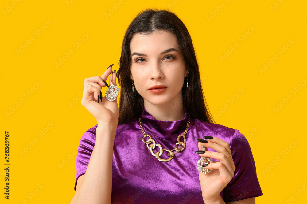 Beautiful young woman with trendy jewelry on yellow background Beautiful young woman with trendy jewelry on yellow background
