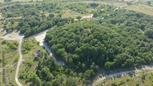 Mezek Tomb - Thracian Tumulus Covered By Green Trees at Mezek, Bulgaria. - aerial shot photo