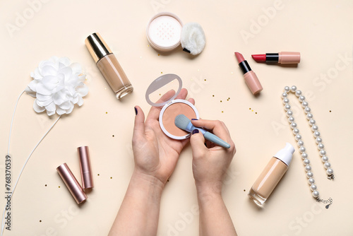 Female hands with different decorative cosmetics and jewelry on beige background