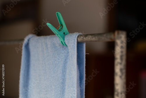 Clothespin and blue towel drying on a clothesline in a room