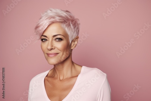 Portrait of beautiful middle aged woman with pink hair on pink background