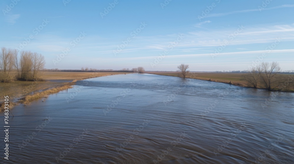 View from the top of a levee with farmland below completely overtaken by the fastmoving destructive floodwaters.