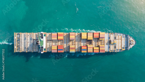 Aerial view of cargo ship with contrail in the ocean sea ship carrying container and running from container international port smart freight shipping by ship service
