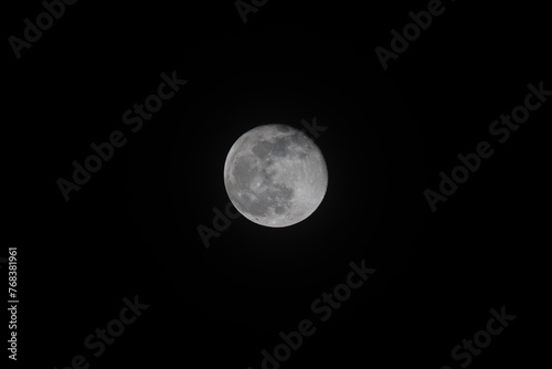 An almost full moon in the winter night sky