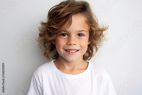 Portrait of a cute little boy with curly hair, studio shot