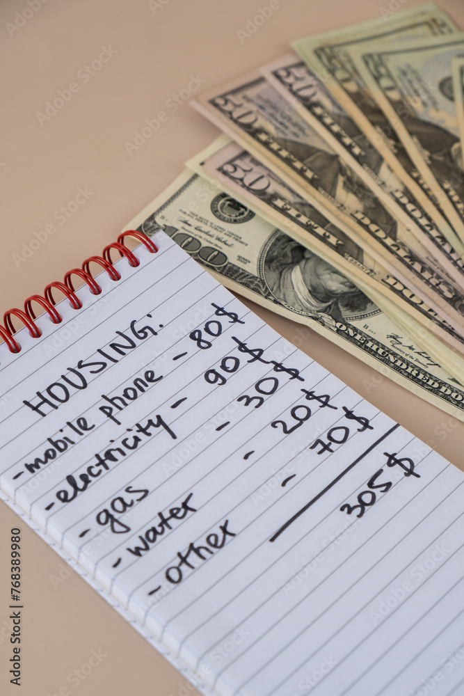 Obraz premium Counting expenses bills on housing electricity, gas, water. Banknotes of dollar cash around. High prices for energy inflation crisis. Cut back on spending. Savings rate
