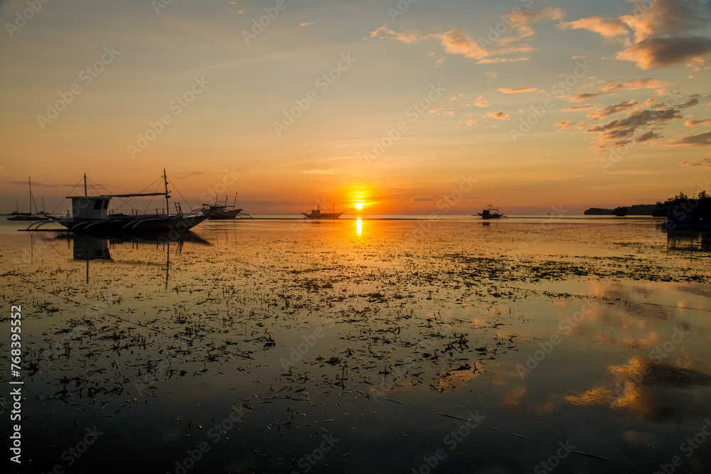 Golden Sunset Serenity. A tranquil beach scene at dusk with boats silhouetted against the horizon. Nature’s beauty in perfect harmony.