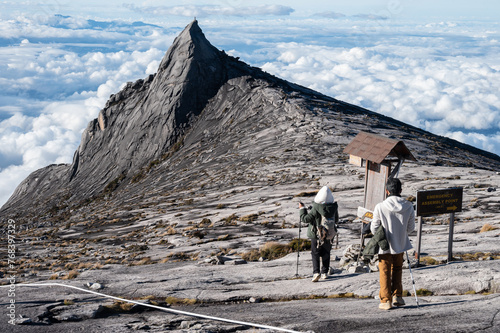 Tourist with an iconic peak named South Peak (3929 m) on Mt.Kinabalu, Malaysia.