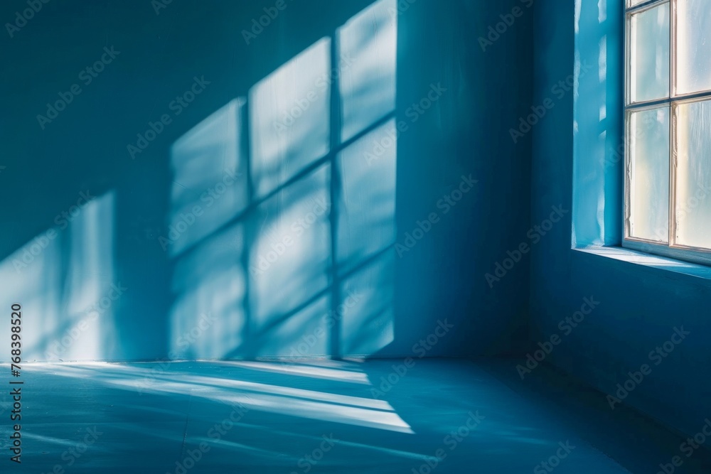 Obraz premium Abstract background with shadows of window on blue wall
