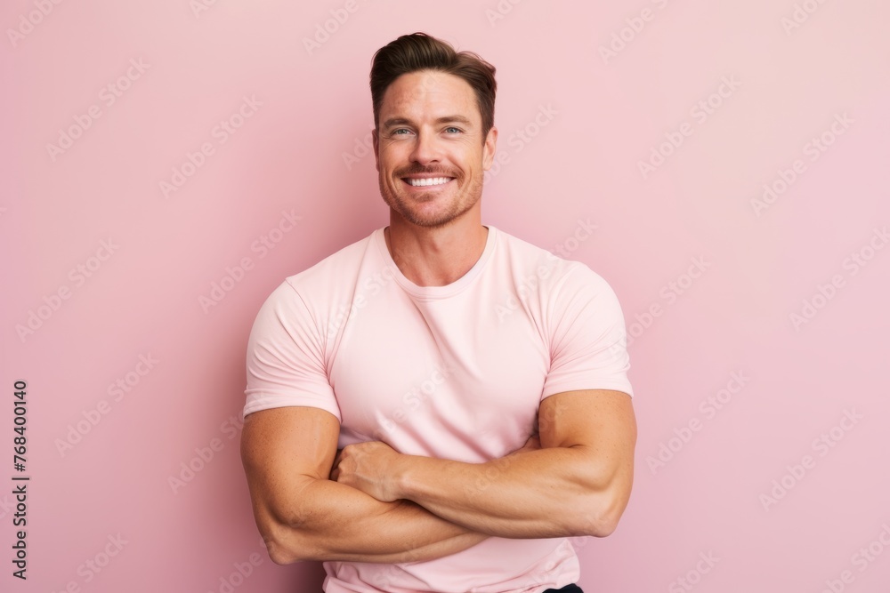 Portrait of handsome young man with crossed arms standing against pink background Portrait of handsome young man with crossed arms standing against pink background