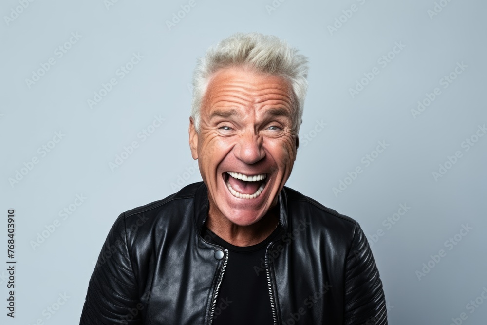 Happy senior man in leather jacket on a grey background. Studio shot. Happy senior man in leather jacket on a grey background. Studio shot.