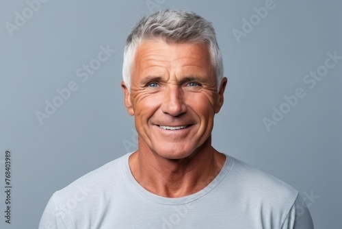 Portrait of a happy senior man looking at camera over grey background