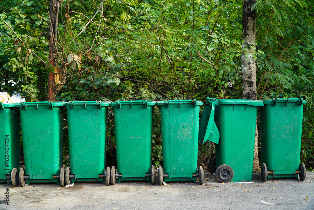 Trash can in the park. Green trash can in the park. Trash can in the park. Green trash can in the park.