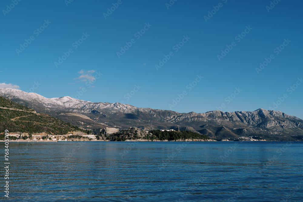 Mountain range with snow-capped peaks on the seashore