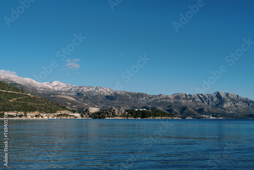Mountain range with snow-capped peaks on the seashore © Nadtochiy