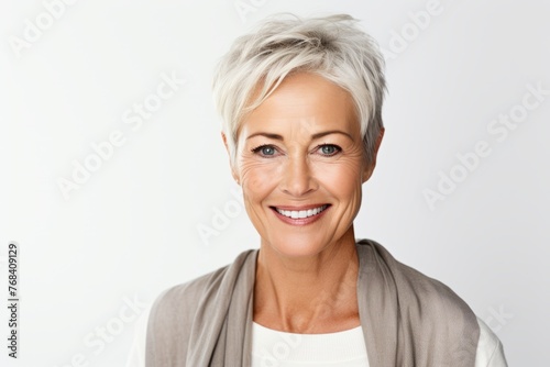 Closeup portrait of smiling mature business woman, over grey background.