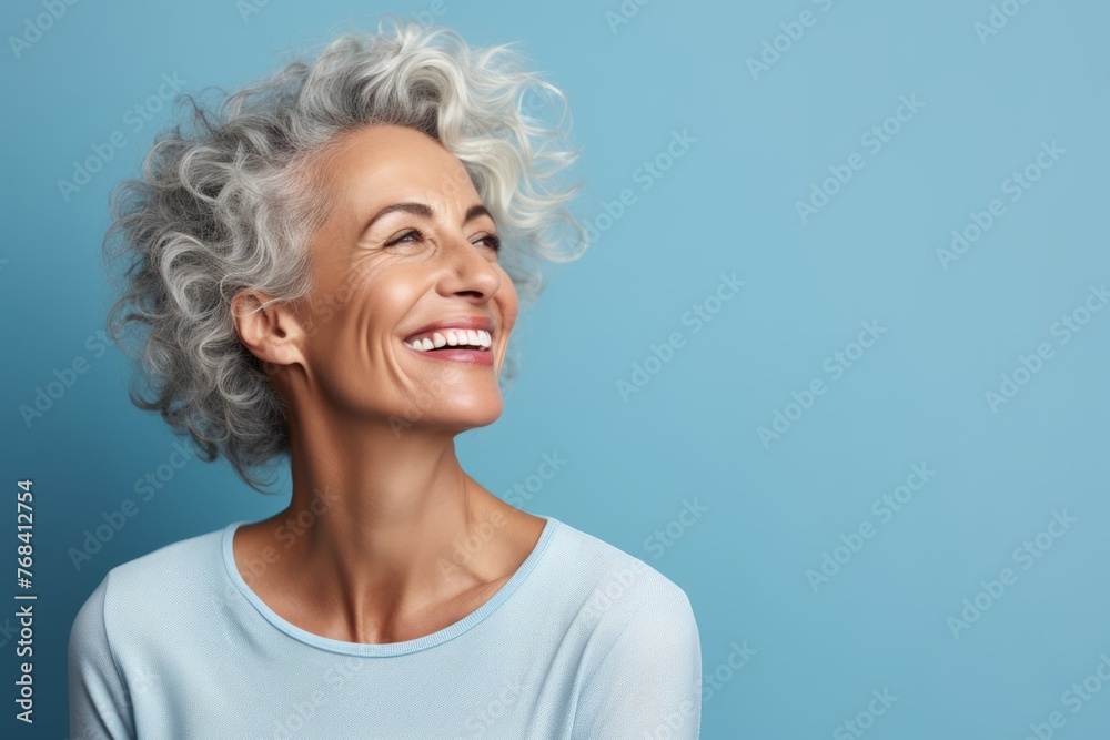Portrait of happy senior woman with grey hair. Isolated on blue background Portrait of happy senior woman with grey hair. Isolated on blue background