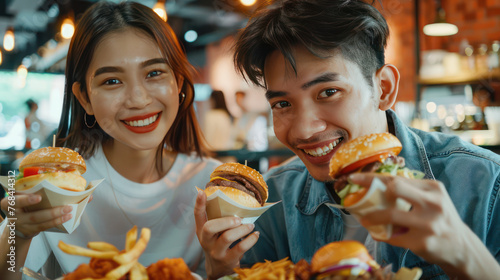 Portrait of a young Asian couple eating street market  fried chicken  burgers