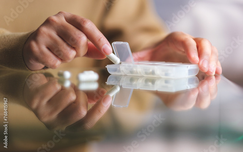 Closeup image of a woman taking pill out from pills box