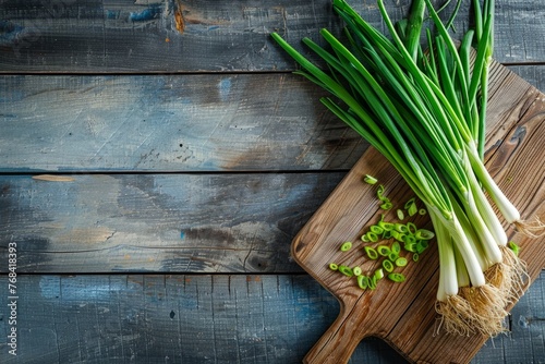 A cutting board on a wooden table  topped with fresh green onions