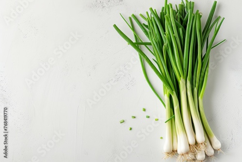 A bunch of green onions neatly arranged on a wooden table in an overhead shot